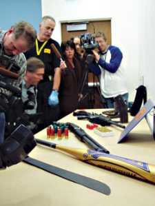 Kyle Huff's arsenal on display at police headquarters. From top: a semiautomatic assault rifle, a pistol-grip shotgun, a baseball bat, a machete, and some 300 rounds of ammo.