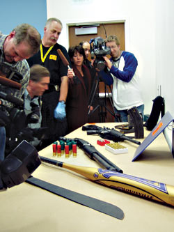 Kyle Huff's arsenal on display at police headquarters. From top: a semiautomatic assault rifle, a pistol-grip shotgun, a baseball bat, a machete, and some 300 rounds of ammo.