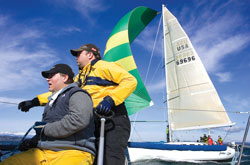On land, Dave Marod (in yellow jacket with crew member Kris Lea) drives a Hummer; on water, he commands a sea-going "Ferrari" named Minor Threat that competes with other high-end sailboats on Puget Sound.