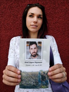 Ashley holds the memorial flyer from  the funeral service for her husband Jared.