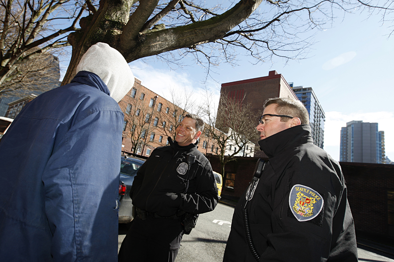 Ever the chatty one, Officer Burns talks to a "client" while Besaw looks on.  Slide show: The Two Seattle Cops Changing the Way Belltown Gets Policed.
