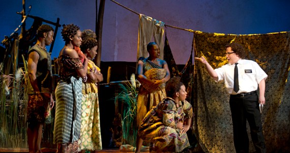 Gertner (at right) lectures the locals about LDS beliefs inThe Book of Mormon.