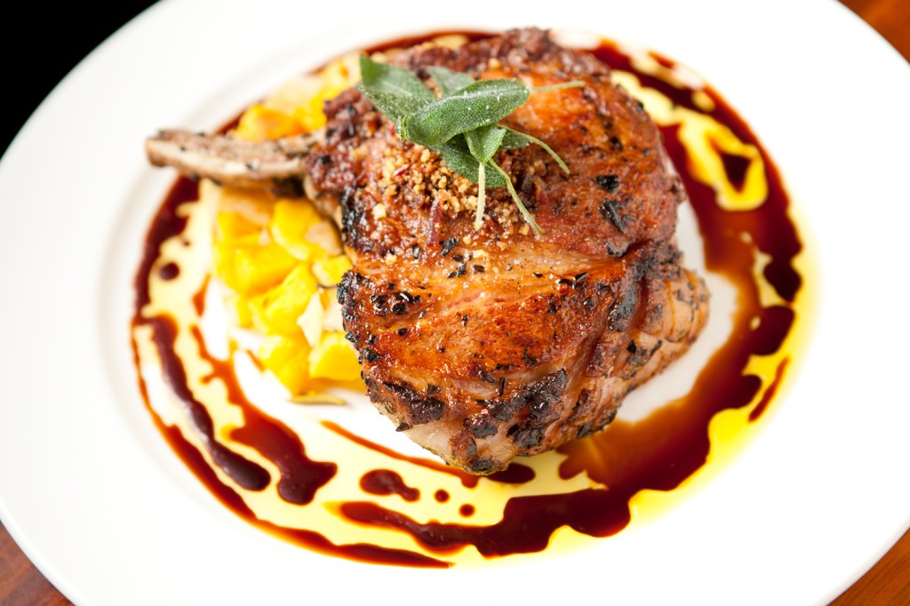 A double chop with a hash of apples and sqash and crowned with crisped sage at Stumbling Goat Bistro (Photo by Joshua Huston)