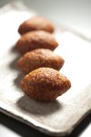 Oblong kibbeh patties, featuring impeccably-spiced beef and a pine-nut crust.