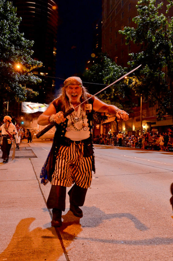 The Seafair Pirates sailed through downtown Seattle along 4th Avenue surprisin', delightin', frightenin', and entertainin' the thousands o' landlubbers that lined its shores durin' the Seafair Torchlight Parade.