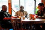 Seattle Police Department Officer John Hayes Jr. (right) and detective James Manning (left) meet with Pastor Greg Bell from the organization Standing in the Gap.  Standing in the Gap held a prayer vigil at the cafe after the shootings.