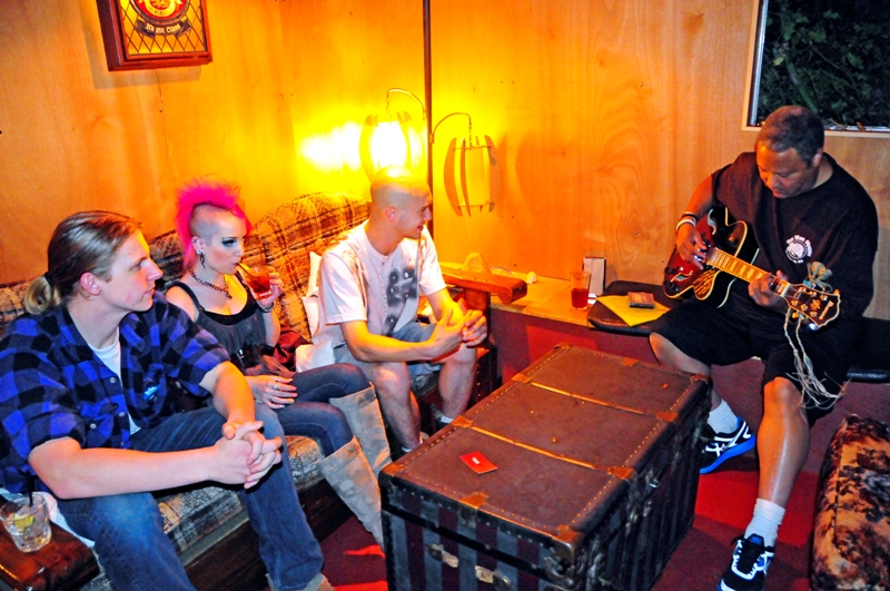 Upstairs, Joseph Williams strums guitar, while Anton Sobolik sings along, with Michelle Genova and Zach Johnson.