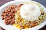 A brick-red bog, humming with the smoky, vegetal flavors of chiles, laps the edges of the red enchilada plate. The beefy sauce engulfs a stack of soft yellow corn tortillas, diced raw onions, iceberg lettuce shreds and grated cheddar cheese. Fleshy, salty pinto beans and two over-easy eggs, primed to infiltrate the gravy with the creaminess peculiar to yolks, round out the dish.
