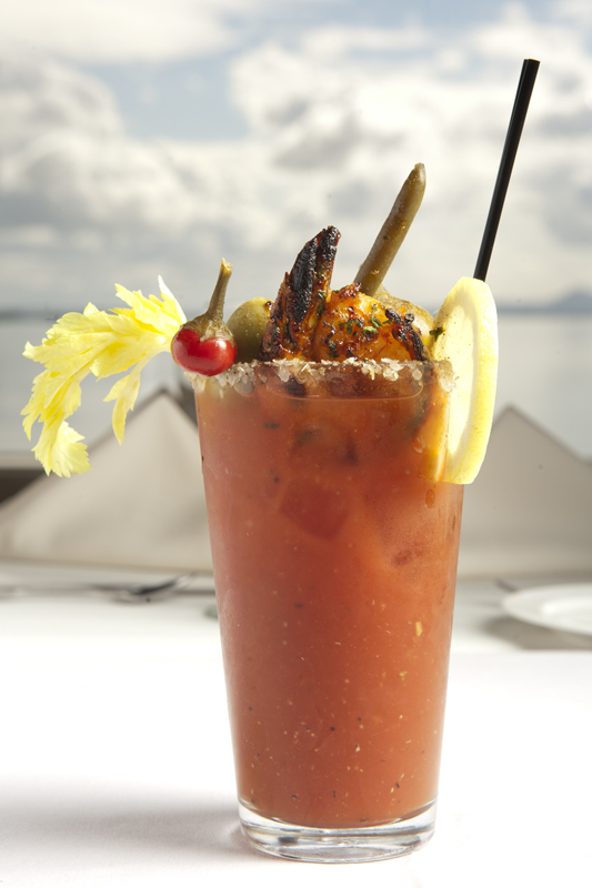 The Chuckanut Manor Signature Bloody Mary garnished with a large spiced wild prawn and salad. The Bloody Mary is made with ancho-chile house infused vodka.
