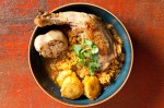 Durbin's terrific chicken thighs, roasted and tossed with starchy plantains, slow-cooked rice and pigeon peas, and a full head of roasted garlic.