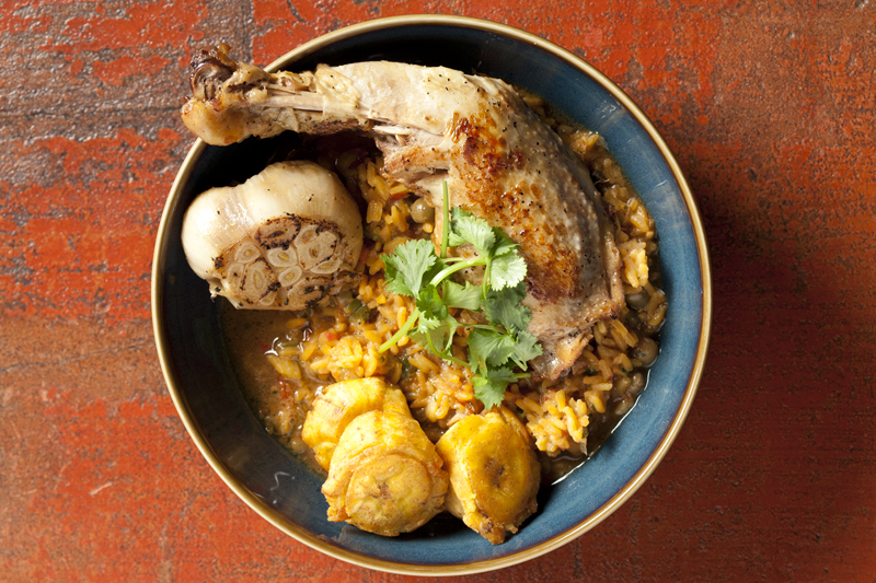Durbin's terrific chicken thighs, roasted and tossed with starchy plantains, slow-cooked rice and pigeon peas, and a full head of roasted garlic.