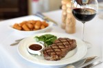 New York steak with truffled tater tots and glass of cabernet sauvignon