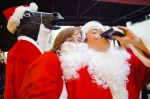 A Santa Claus hydrating along the parade route.