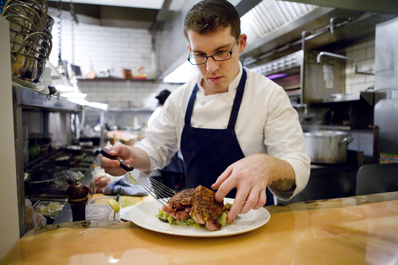 Chef Quinton Stewart platting up the pork shoulder.