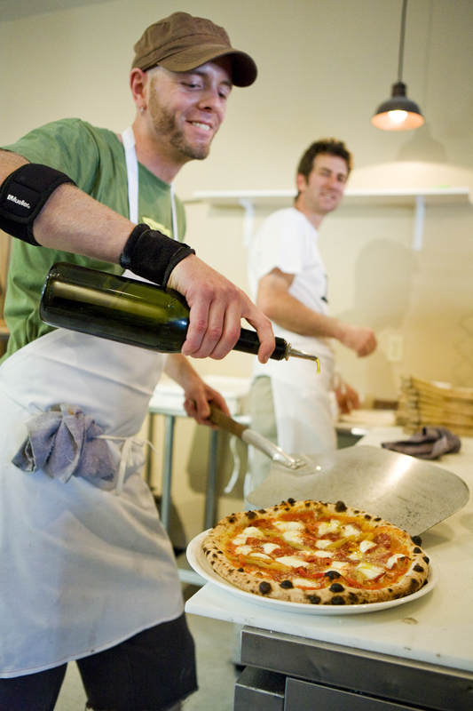 Cook Toby adds olive oil to a Margherita Pizza at Bar del Corso