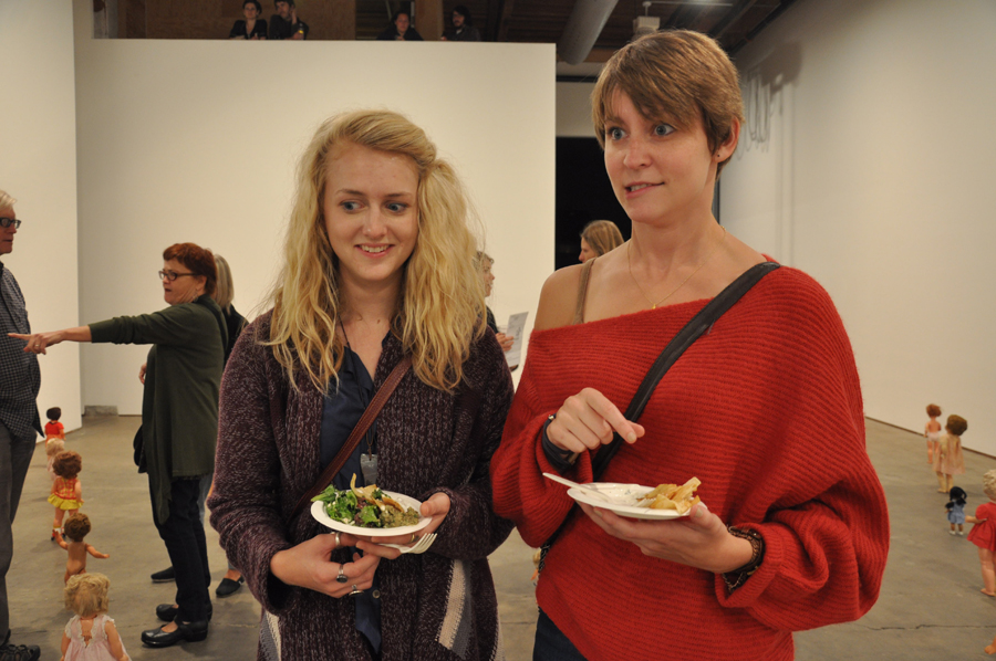 Seattle University senior visual art student Colleen Clement and Emily Frost recoil at the creepiness of 113 dollsaE™ faces looking up at them.