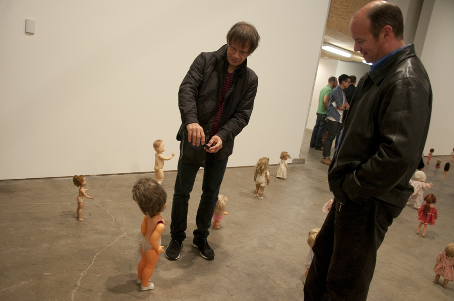 Wyn Bielaska takes a photo of the beehive doll as his companion Mark looks on.