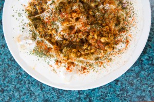 Mantoo Pasta filled with ground beef, onion and spices topped with meat sauce, garlic yogurt, and dried mint.