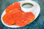 Paukara Potato fitters-thinly sliced potatoes dipped in beasan flour batter, fried and served with cilantro chutney.