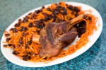 Qabili Basmati rice mixed with carrots, raisins, and topped off with a lamb shank.