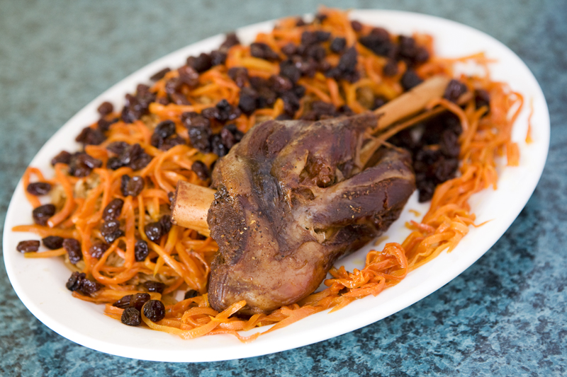 Qabili Basmati rice mixed with carrots, raisins, and topped off with a lamb shank.