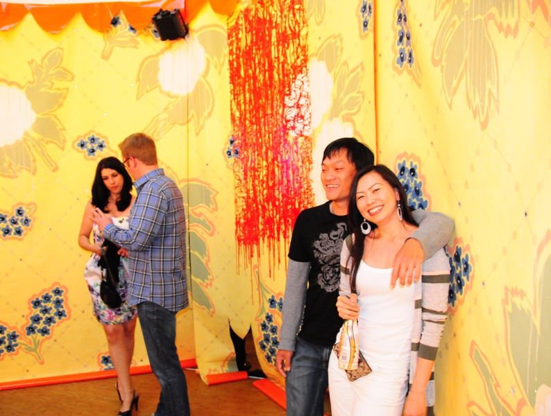 People pose for photos in front of Julia Freeman's artistic wallpaper.