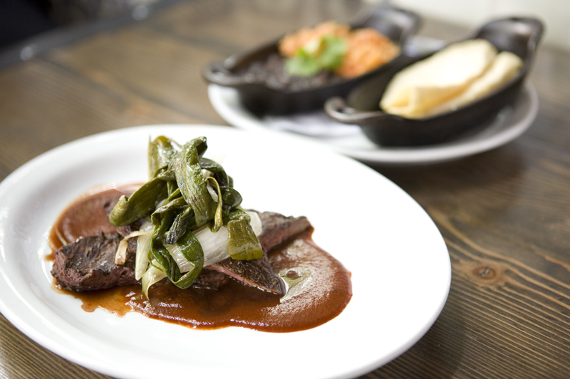 Carne Asada: Painted Hills skirt steak grilled medium rare, guajillo sauce, grilled knob onions. Served with rice, beans, and house made tortillas.