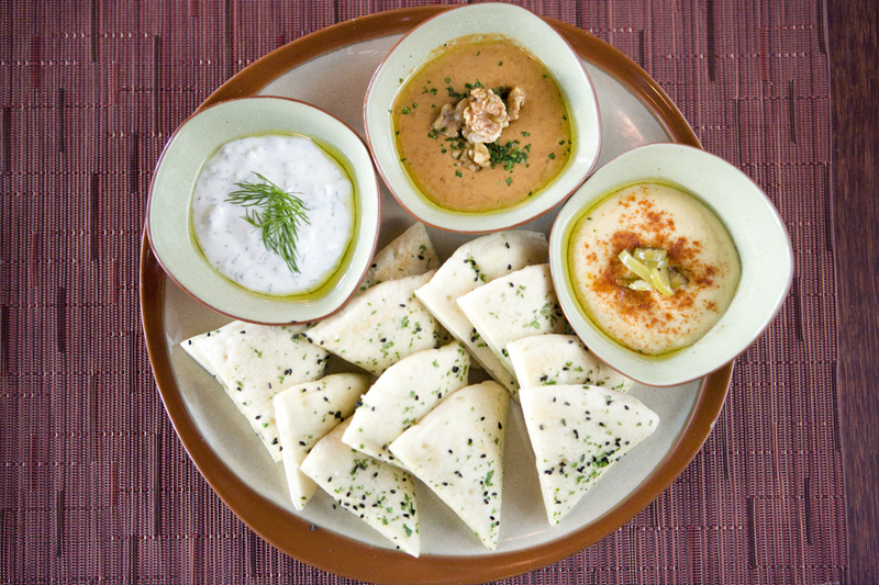 Flat Bread accompanied by hummus, walnut and pomegranate, and garlic and herb yogurt dips.