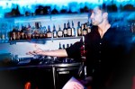 Pnk Ultra Lounge Bartender Blake Webb shows off behind the bar, turning a bottle of booze into a baton.