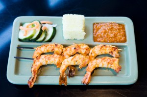 NamaE™s Prawns, marinated and grilled, served with a Cambodian dipping sauce, rice cake, and pickled cucumbers.