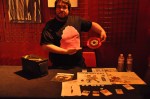 Felix from The Mumlers works the merch booth, showing off the band's bright pink Coffin Factory LPs.