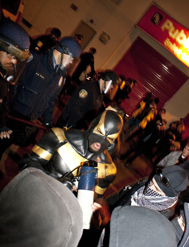 Phoenix Jones trying to get protesters to move away from the police line and head the other direction. Jones was trying to de-escalate conflicts between the police and protesters. Some protesters saw him as an enemy to their causes.