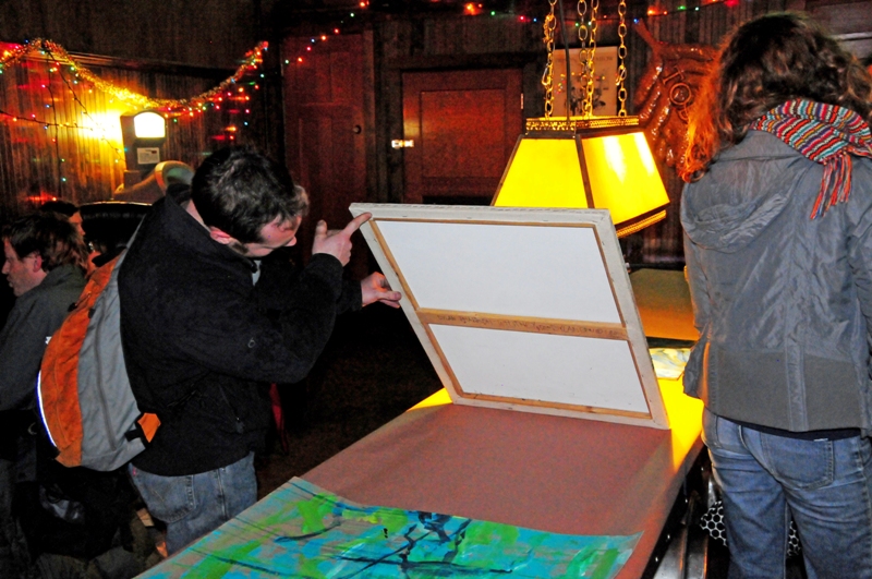 A potential buyer checks out the price for a painting by Dylan Pharaoh-Whitney.