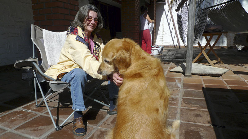 Sandi, pictured with a golden retriever named Yuppy, operates an aftercare facility. Patients who aren't ready to return home after ten days of rehab at Pangea Biomedics come to Sandi for booster doses of ibogaine and additional therapy.
