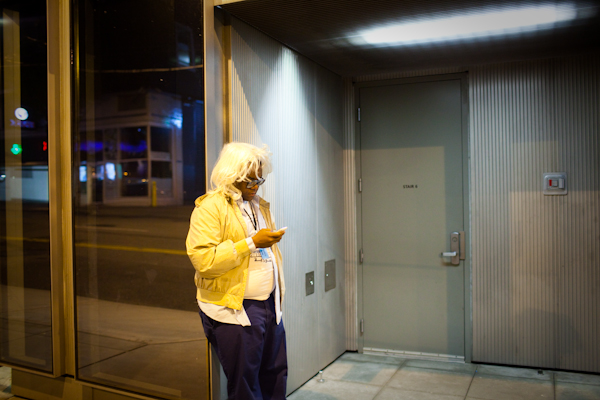 A man in a wig texts outside of the Seattle Art Museum during the SAM Remix in Seattle, Wash., on Friday, June 4, 2010.  The event included the "Pop Culture Fashion" runway show, music with DJ Riz, and many more activities and performances.  (Photo by Matthew Williams for The Seattle Weekly)