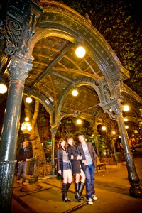 Partiers pose under the landmark glass and cast wrought iron pergola - originally built in 1909. In 2001, an 18-wheeler hit and demolished the pergola, which was then rebuilt.