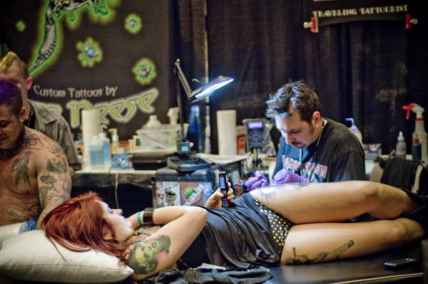 Texting and inking at the National Tattoo Convention.