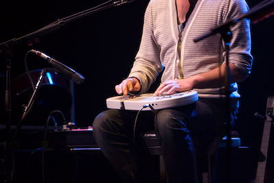 Jemaine on some sort of instrument form the future.
