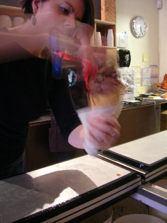 Owner Molly Moon scooping a cone of Molly Moon's Homemade Ice Cream  Shop's Baracky Road ice cream, a blend of chocolate, hazelnuts and  enormous marshmallow chunks. The shop is located in Wallingford.