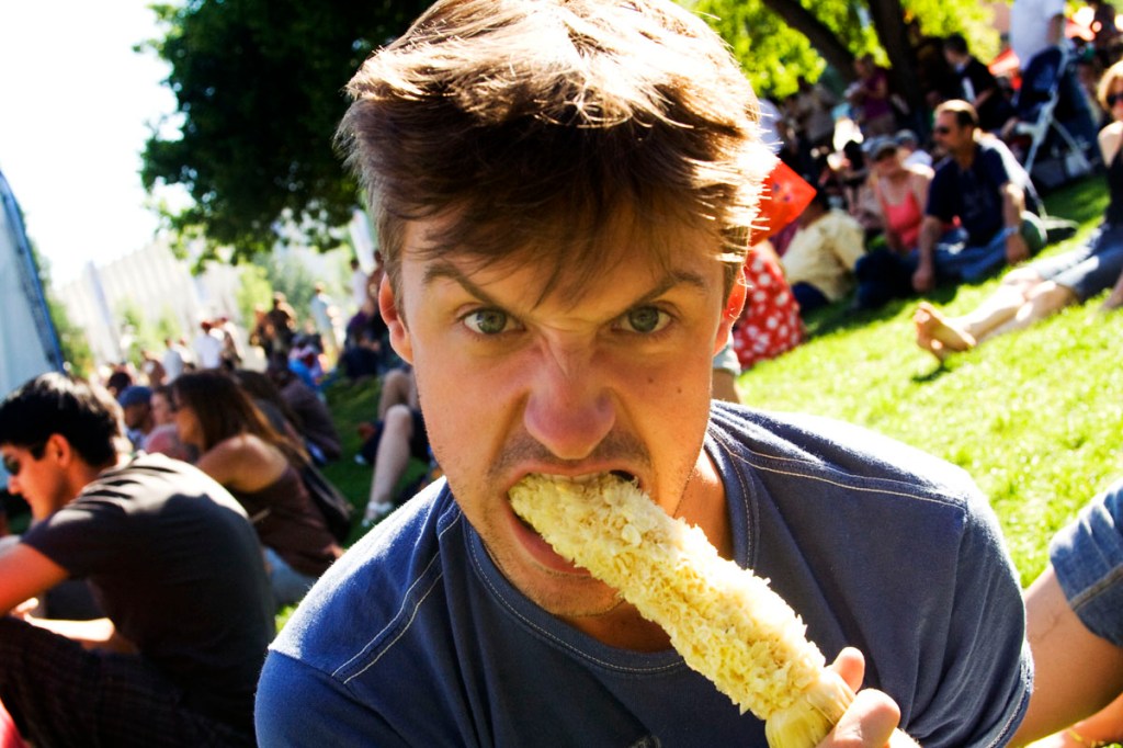 John chomps on an ear of corn.