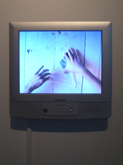A video of two hands belonging to two different people making a paper airplane: Andrew Kauffman's Conquest of the Air at PUNCH Gallery.
