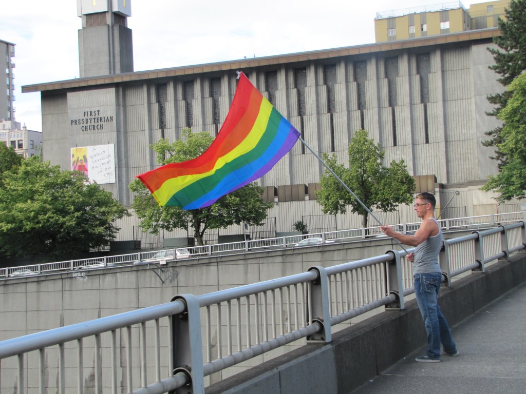Rainbow flags soar overhead as “Celebrate” by Kool & The Gang and
