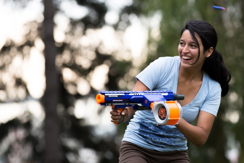 Caitlin Singer dodges a foam dart while advancing on a group of red team members.