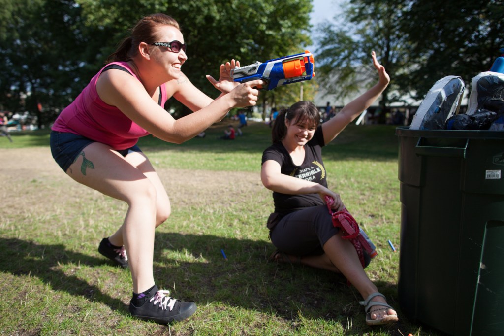Becky Jones reaches to fire over an obstacle while teamate Kat searches for a tag-in.