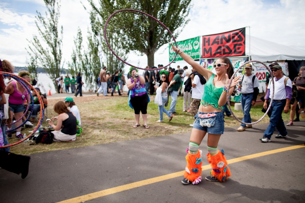 Sophia Lozeau of Seattle hoola hoopes her way down the main path at Hempfest on Saturday.