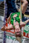 A dancer slides down a stripper pole on the main staged during a performance.