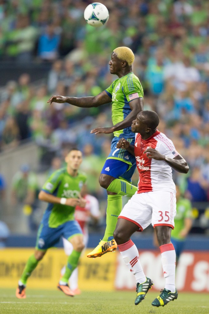 Seattle's Eddie Johnson goes up against Timbers defender Andrew Jean-Baptiste for control of the ball.