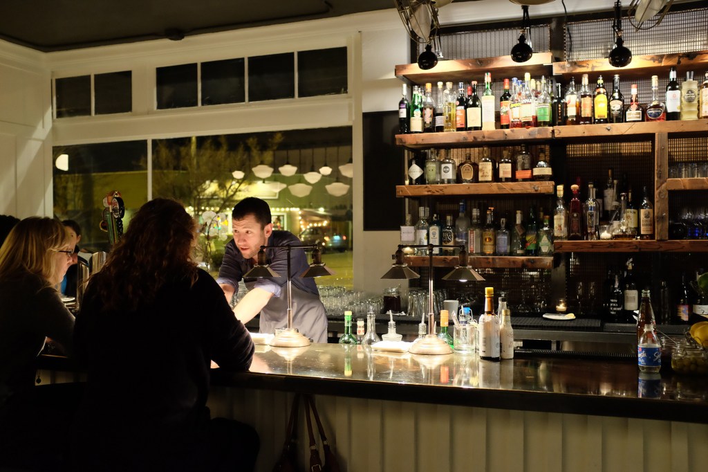 Top, a warm vibe. Bottom left, bartender Jeff Steiner. Bottom right, a floor of shiny pennies.