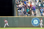 Angels outfielders bobble a deep hit to center field as Seattle fans cheer.