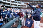 Mariners' manager Lloyd McClendon tosses baseballs into the crowd after the game.